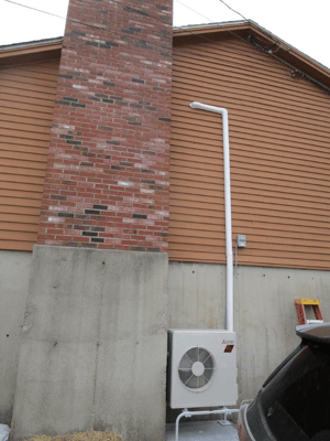 Example of an outdoor condenser and heat pump for a ductless AC system in a split-level home. 